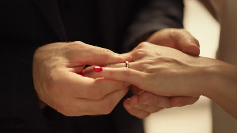 man putting ring on girl's finger