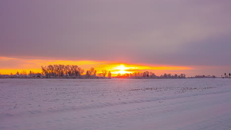 Picturesque-winter-landscape-with-leafless-trees-,flying-clouds-and-golden-sunset-in-background