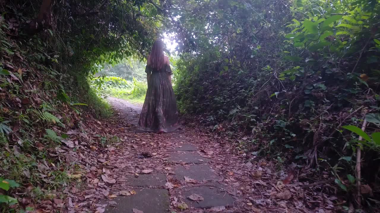 Young woman in long dress walking happily in nature and enjoying life, looking into camera and lifting arms. Bali touristic place in Ubud, ridge walk