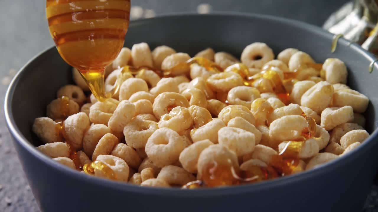 miel vertiendo en un tazón de cereales 4k
