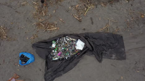 Aerial-rises-from-tarp-of-trash-during-beach-clean-up-event-in-Bali