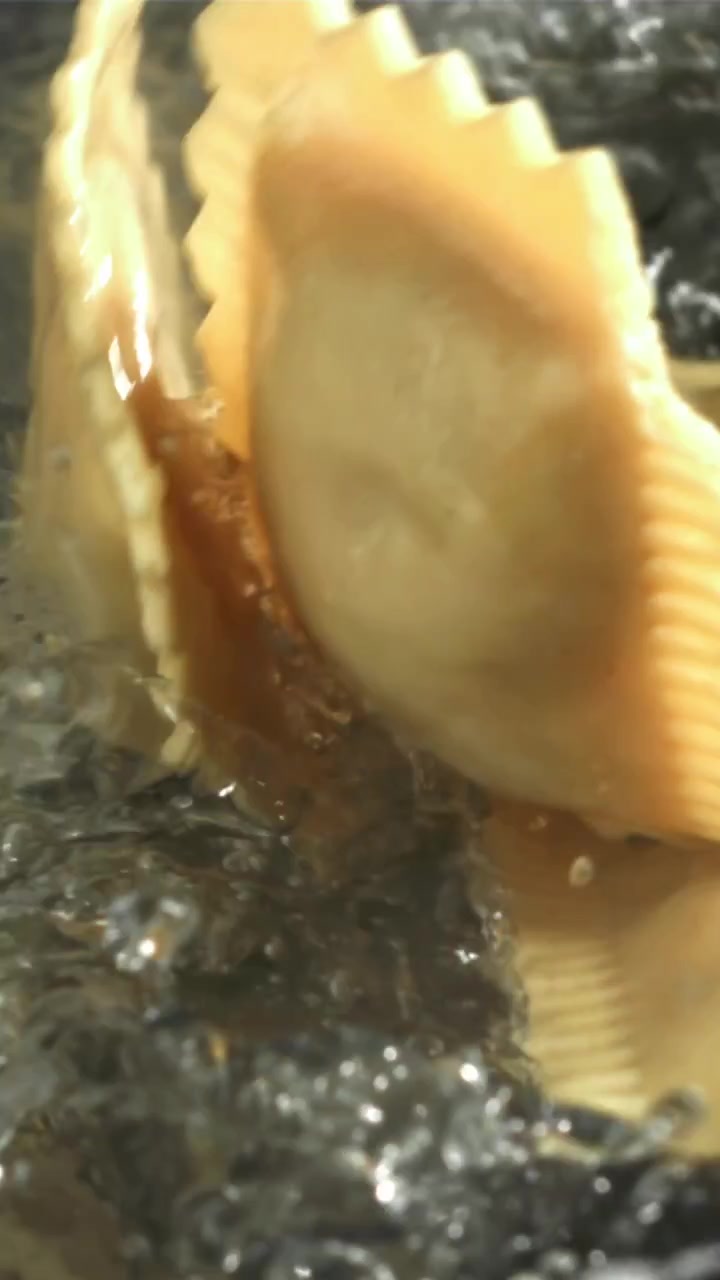 沸騰したお湯にスローモーションで落ちる新鮮なラビオリ。