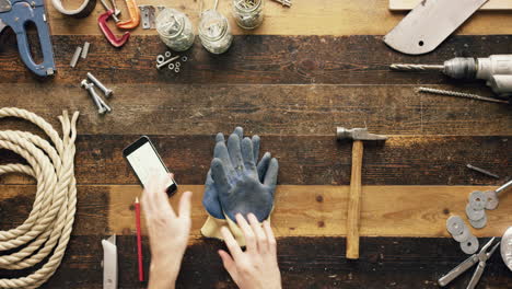 top view artisan craftsman hands using smartphone touchscreen viewing building plans from above - red epic dragon