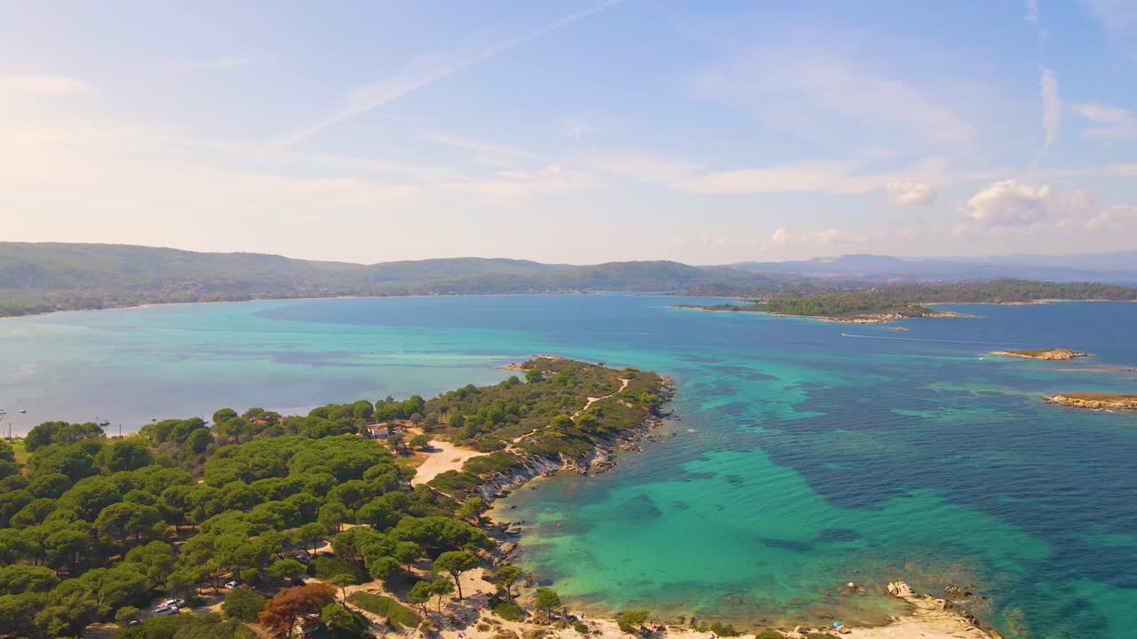 Ripresa aerea con drone che si muove all'indietro sopra una spiaggia esotica a Vourvourou, Calcidica, Grecia