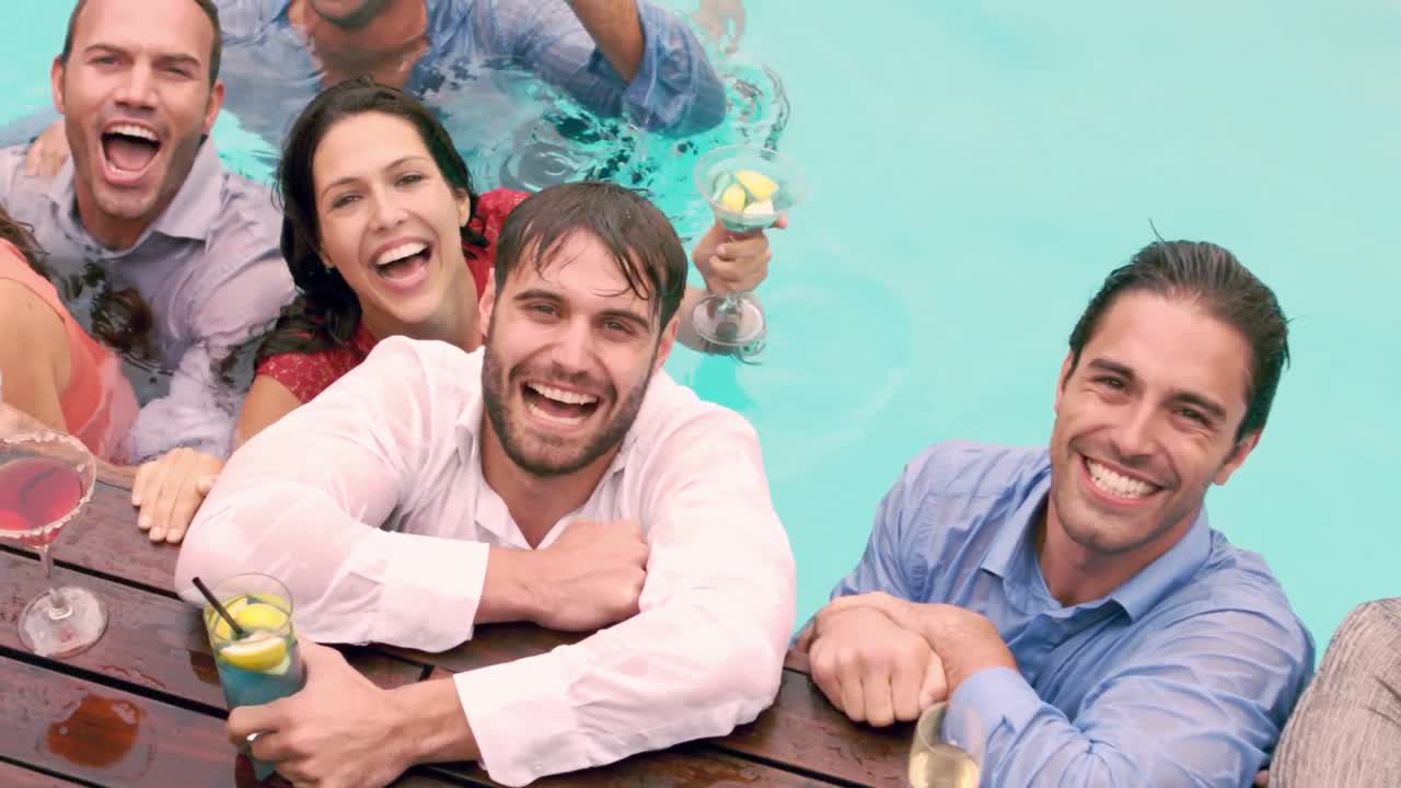 amigos felices tomando una copa en la piscina
