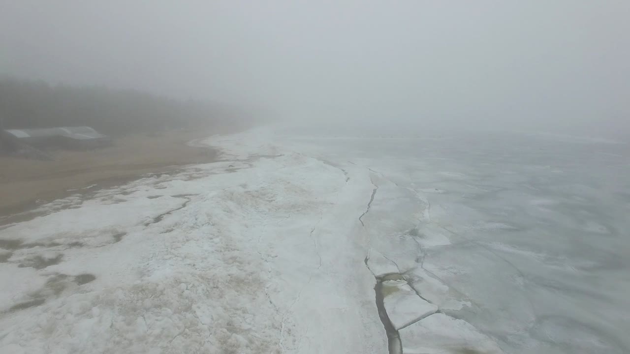 외로운 남자는 얼어붙은 바다 해안의 눈과 얼음을 걸어다닙니다.