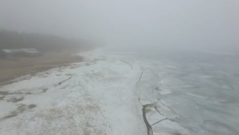 lonely man walks through snow and ice of frozen sea coastline
