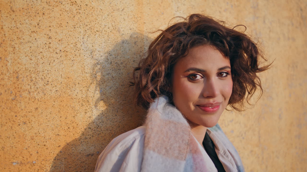 cámara de primer plano de bruneta alegre en la cálida luz del sol. mujer elegante feliz