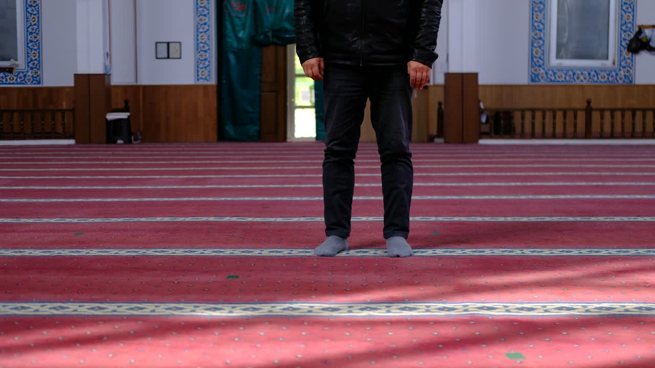 가면을 쓴 노인이 모스크에서 기도하는 동안 무릎을 꿇고 있다 1