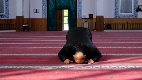 masked old man kneels during prayer in mosque 1