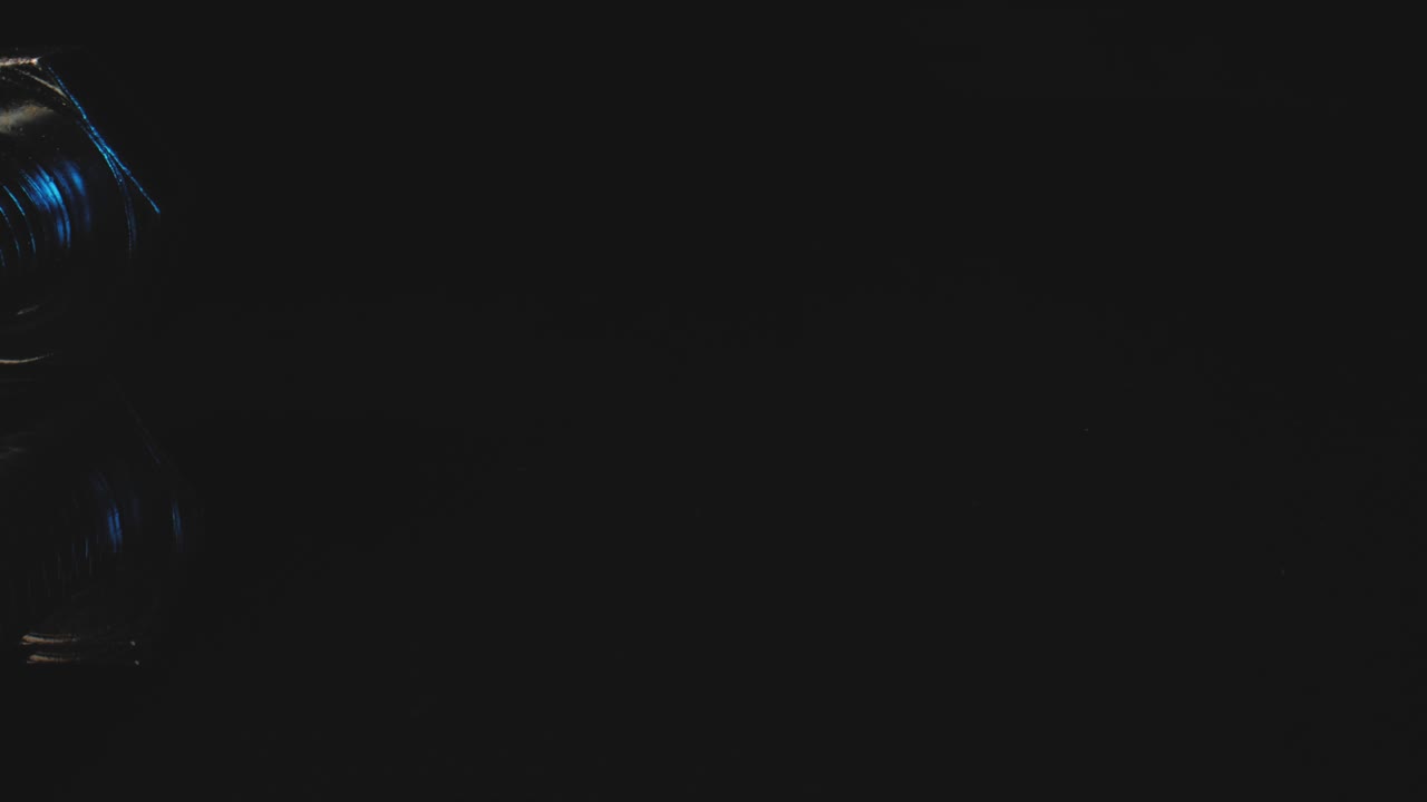 toma macro del hilo de metal en una superficie reflectante negra usando una lente de sonda