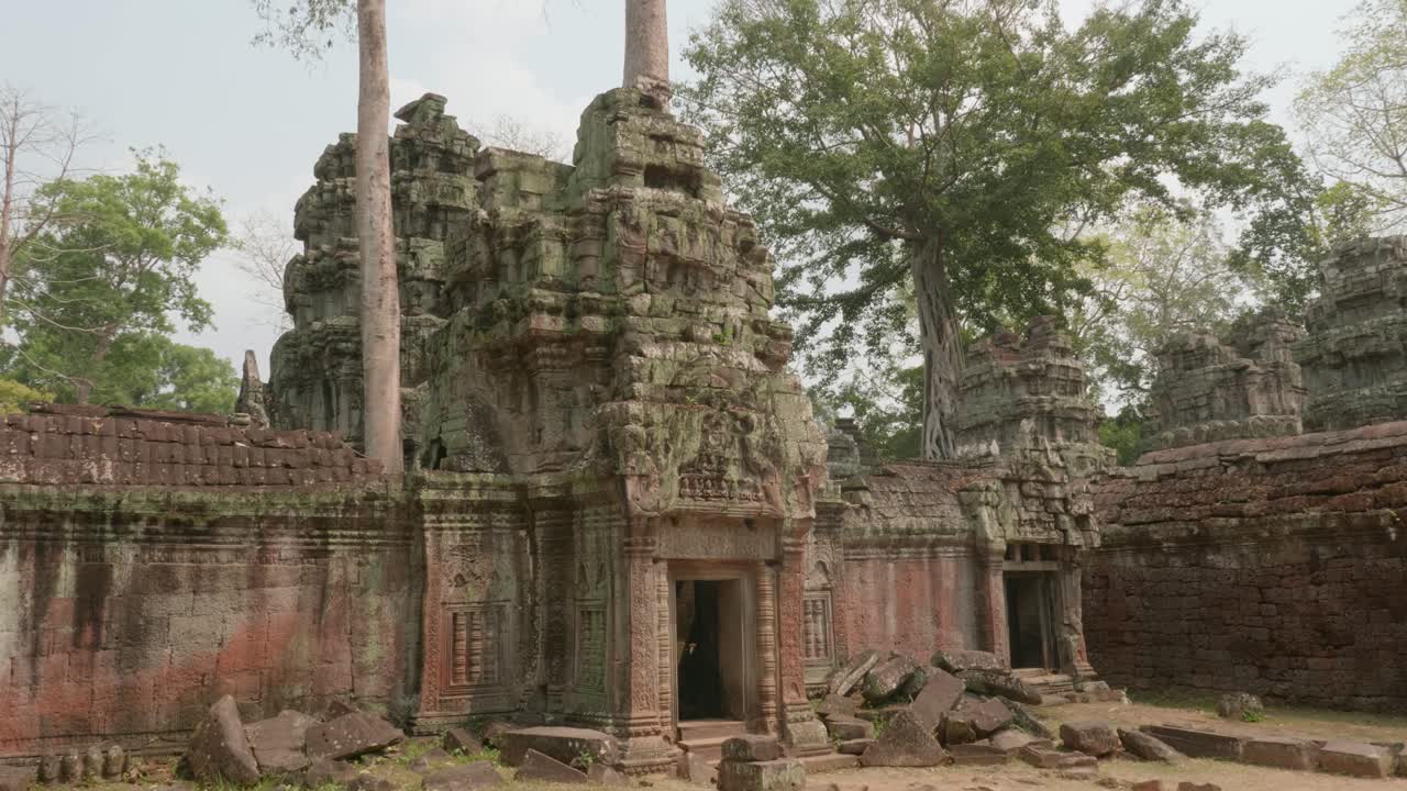 Marchant à l'extérieur d'une entrée avec des blocs cassés gisant sur les côtés, à l'intérieur des temples d'Angkor. 4K