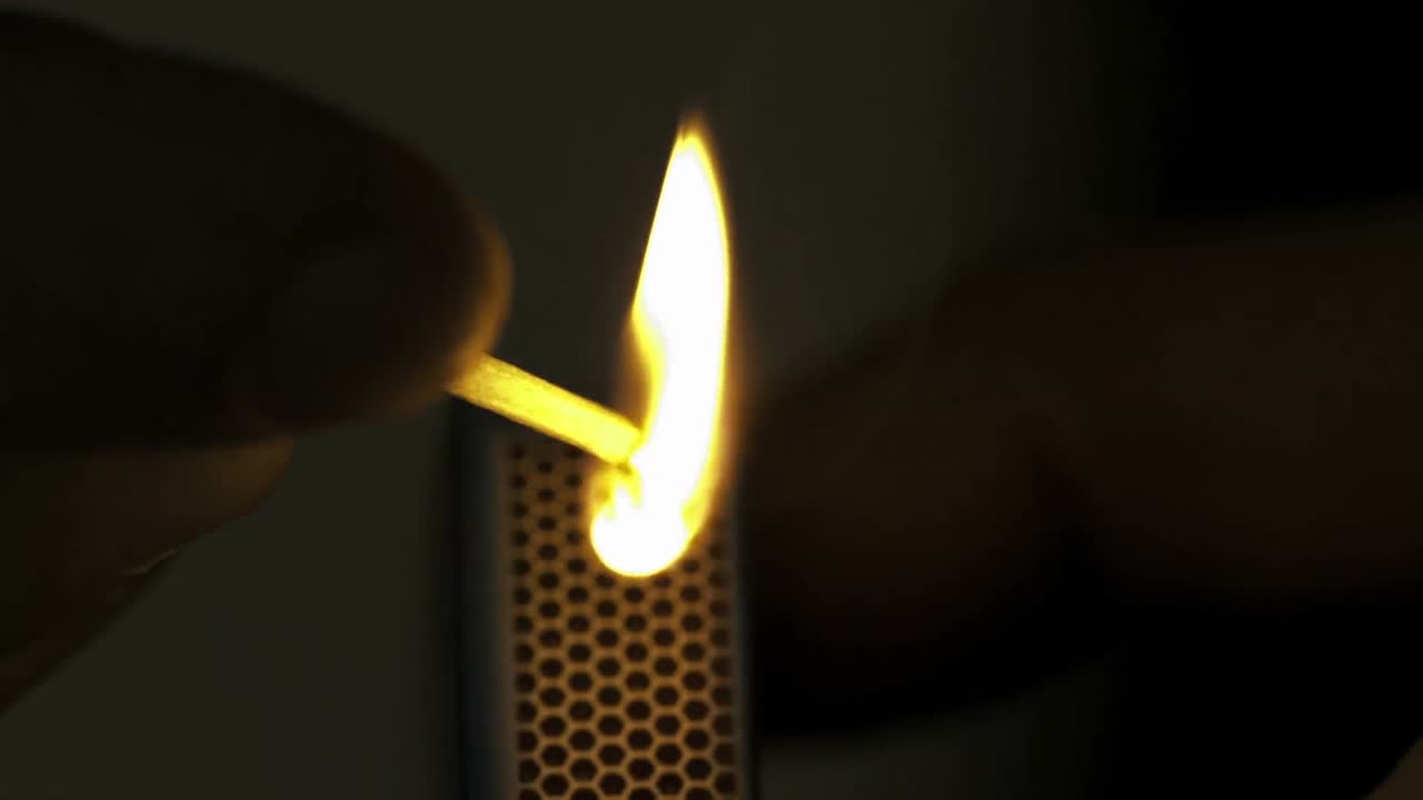 un fósforo encendido en la oscuridad en cámara lenta