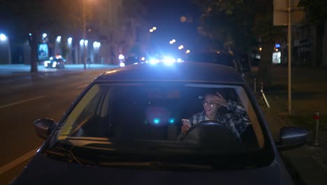 woman driving at night, using phone