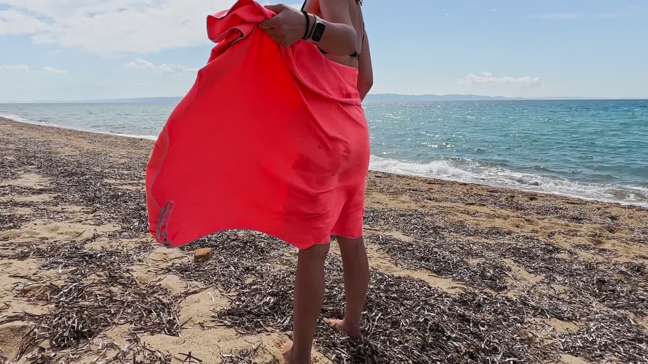 Beautiful woman drying herself with a towel on the beach