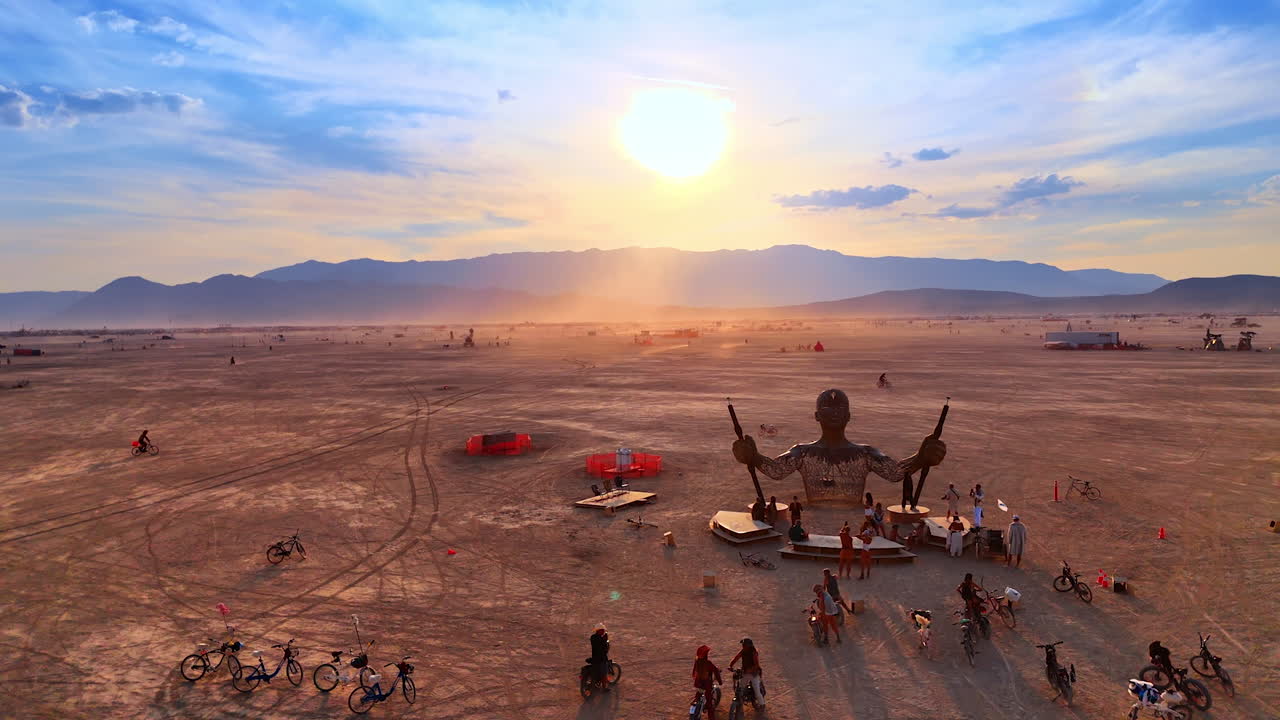 Nevada, USA, 14 August 2025: Large sculpture and sunset view at Burning Man festival in Nevada desert.. A human figure sculpture stands on the playa at sunset