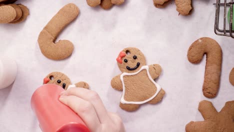 decorando galletas de pan de jengibre con glaseado real para navidad.
