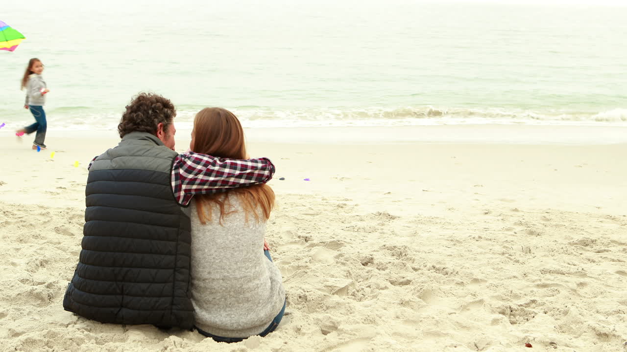 부모 가 앉아 있을 때 아이 들 이 카이트 를 가지고 놀고 있다