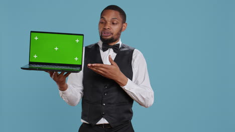 Doorkeeper-bellboy-holding-a-laptop-with-green-screen-in-studio