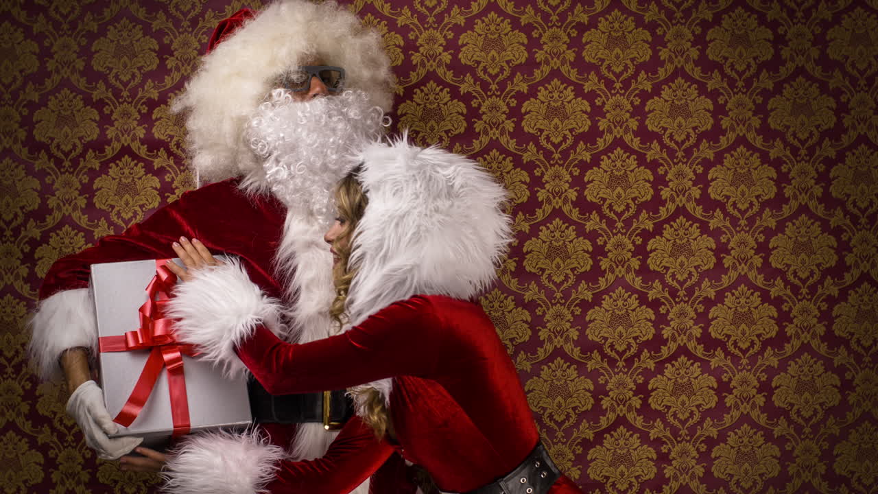 Babbo Natale e una donna in costume natalizio ballano per un servizio fotografico a tema discoteca natalizia