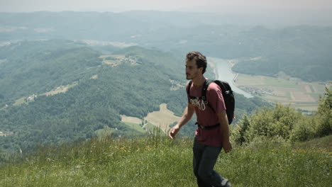 a young hiker walking past the camera from right direction to the left