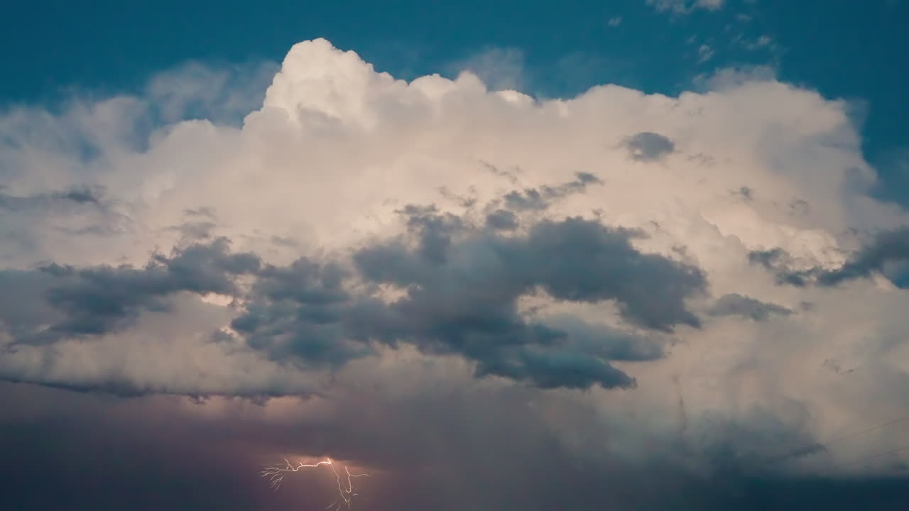 Heavy rainstorm with flashes of light breaking through dense storm clouds