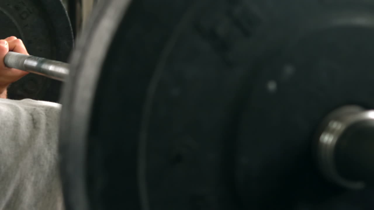 Fit man lifting heavy barbell weight