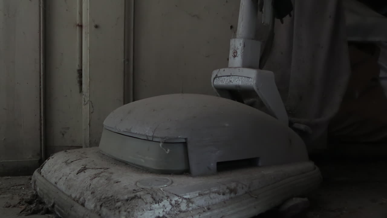 오물과 흙으로 뒤덮인 오래된 빈티지 진공 청소기, 위로 기울이기