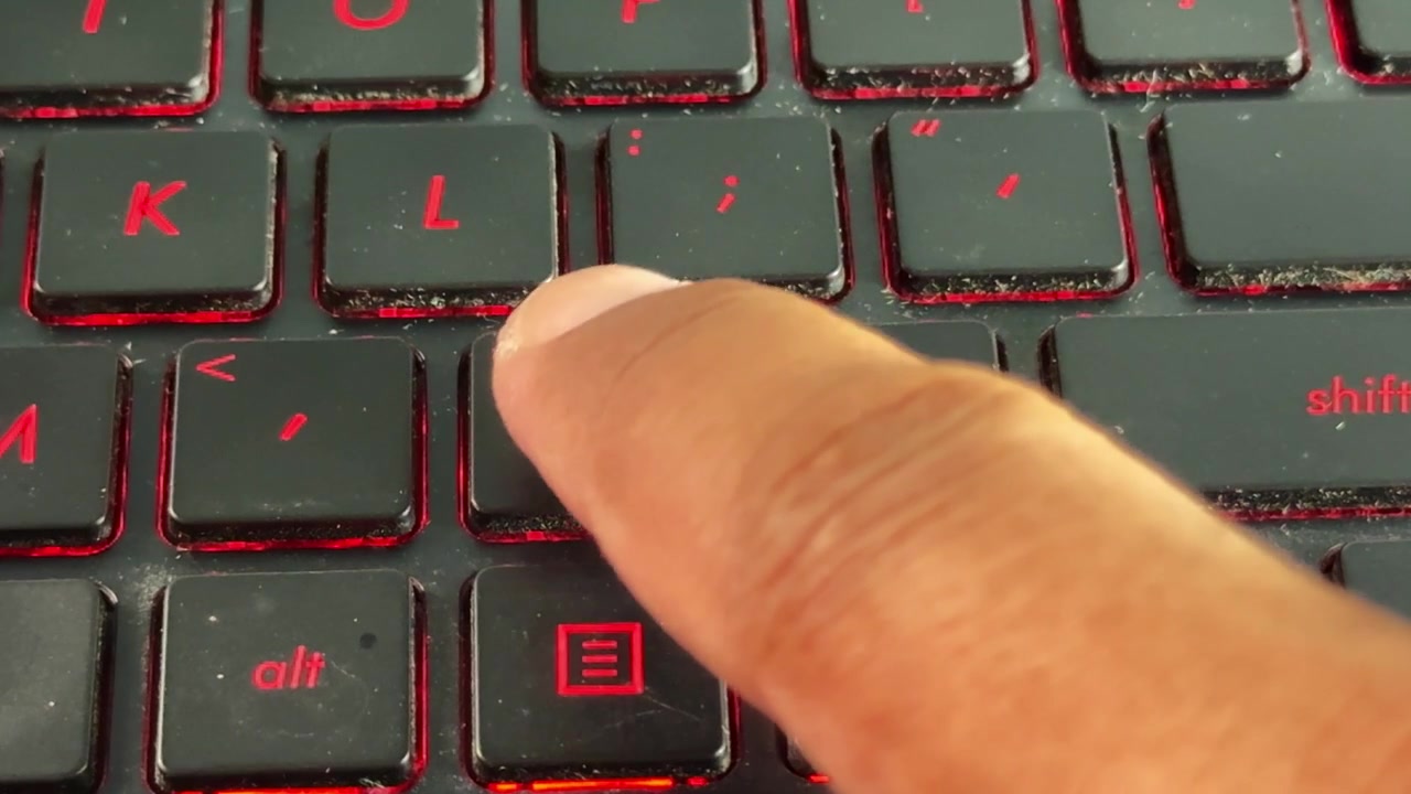 Tastende fingre på moderne tastatur på "punktum"-knappen, der viser computerbrug, teknologi og daglig arbejdsgang.