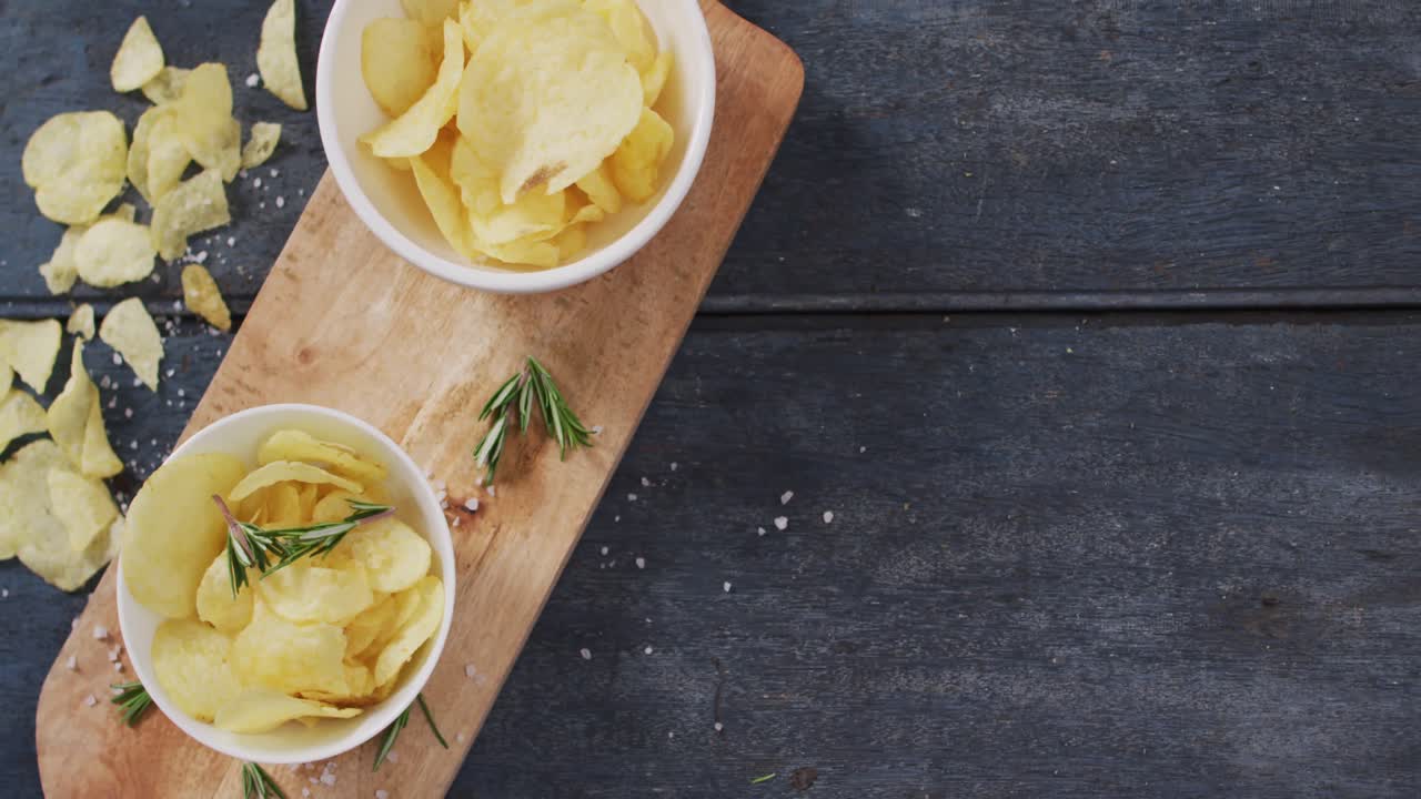 Close up view of two bowls of potato chips on wooden tray with copy space on wooden surface