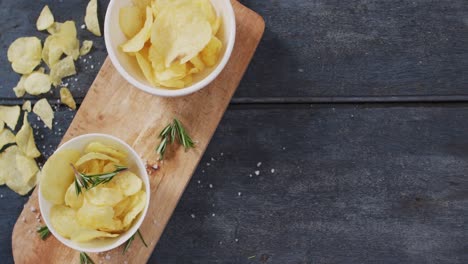 Close-up-view-of-two-bowls-of-potato-chips-on-wooden-tray-with-copy-space-on-wooden-surface