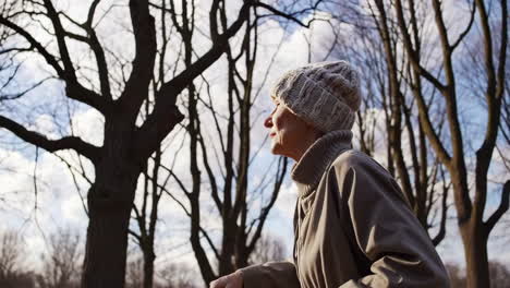 senior woman walking in a park on a cloudy winter day