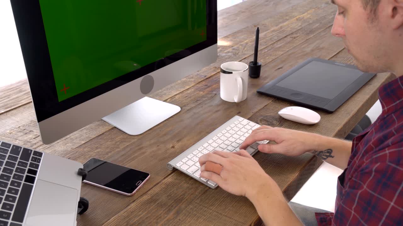 The freelancer male typing with green screen display
