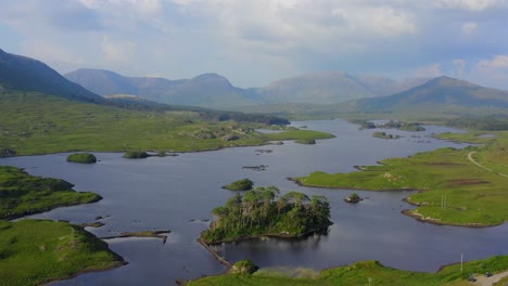 pine island, derryclare lough, connemara, county galway, july 2021. drone slowly orbits pine island, facing east with the twelve bens mountains in the distance