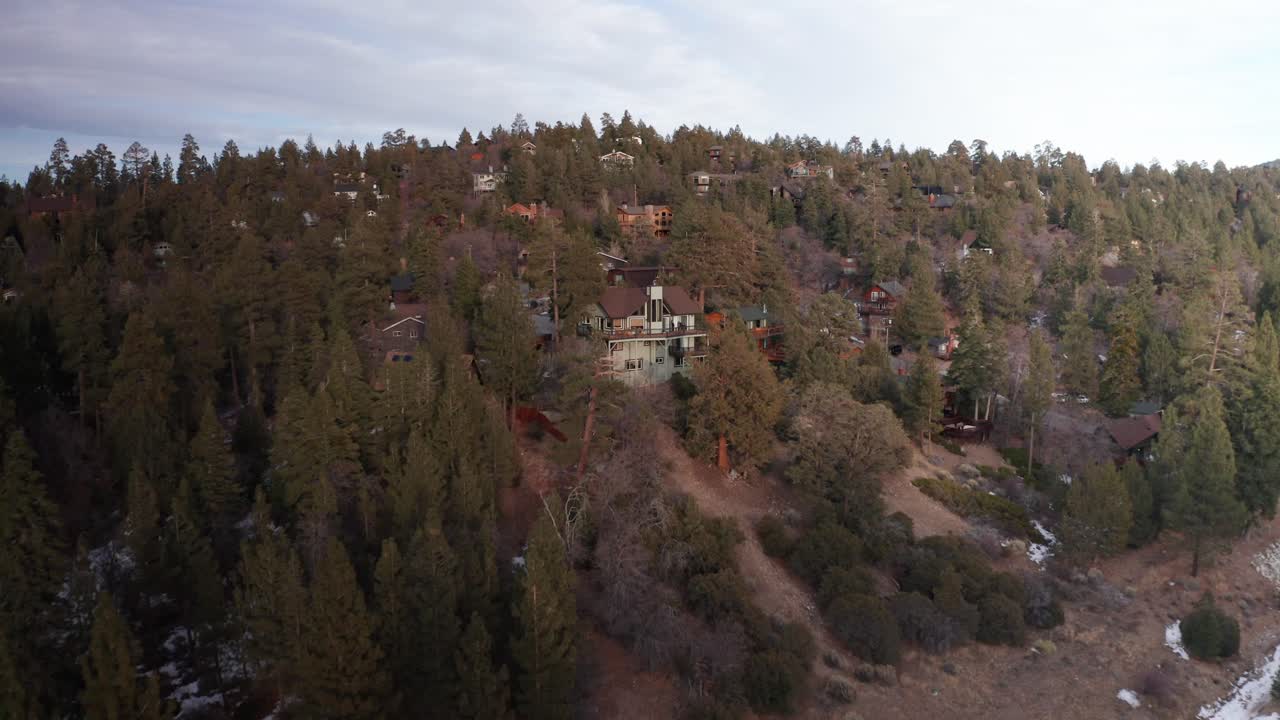 fotografía aérea de una hermosa cabaña de montaña con vistas al bosque alpino durante el invierno en big bear lake, california