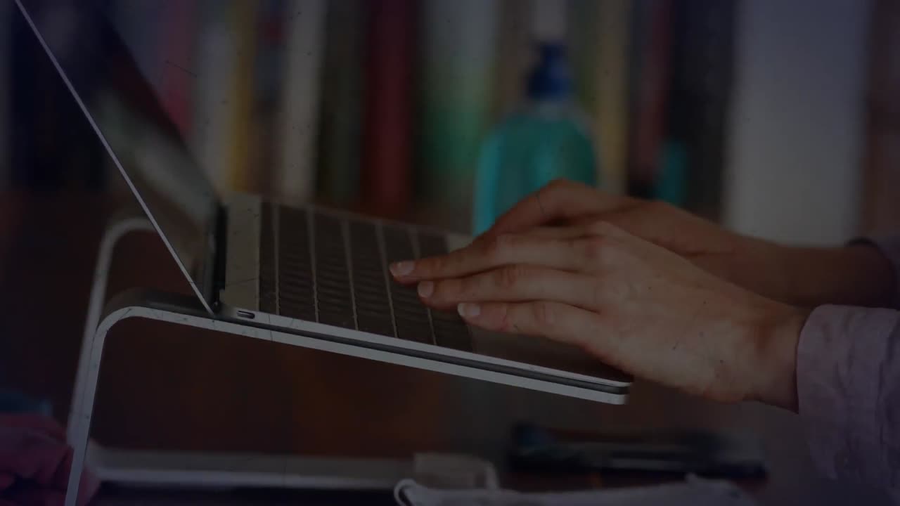 animación de formas sobre una mujer de negocios biracial usando una computadora portátil