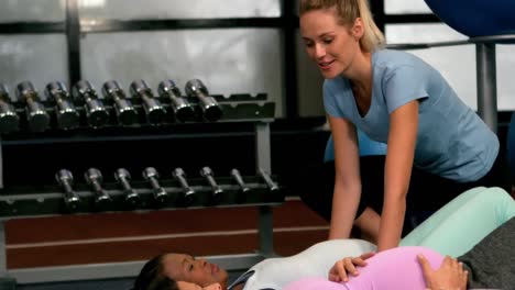 entrenador de fitness ayudando a las mujeres embarazadas a entrenar