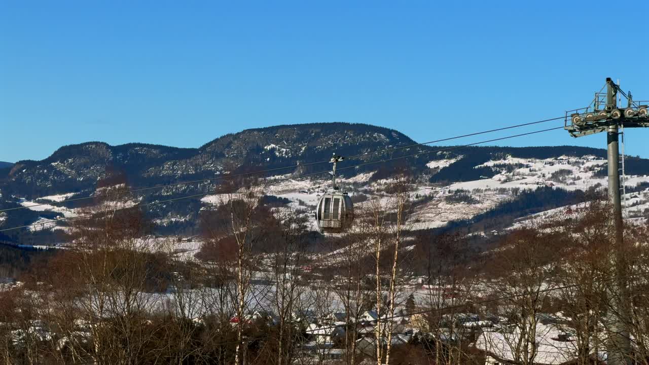 Hafjell Apline Resort Norway Norge winter gondola lift ski snowboard Øyer mountains Lillehammer early morning blue sky Lillehammer mountain range Birch pine trees Sjusjoen mountain valley pan left
