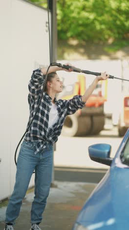 woman washing a car at a self-service car wash