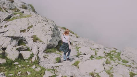 una joven excursionista sube montañas con una cámara fotográfica. transfagarasan, montañas de los cárpatos en rumania