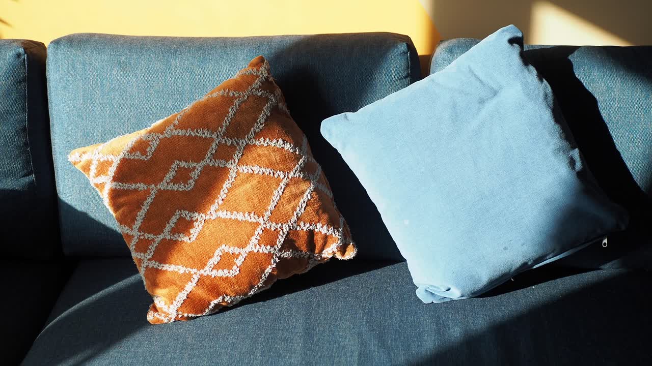 acogedora sala de estar con sofá azul y almohadas naranjas y azules