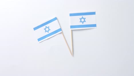 close up of two flags of israel lying on white background with copy space