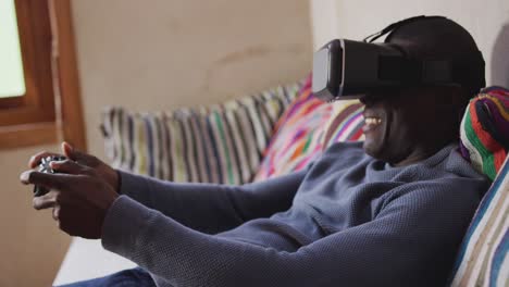 hombre afroamericano que usa auriculares vr en casa