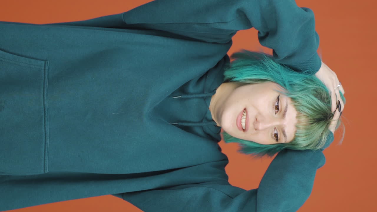 카메라 앞에서 신경 ⁇ 약을 겪고 있는 젊은 여성의 수직 비디오.