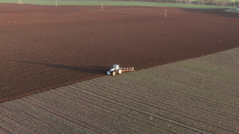 aerial view of a farm tractor ploughing a field in aberdeenshire on a sunny day, scotland