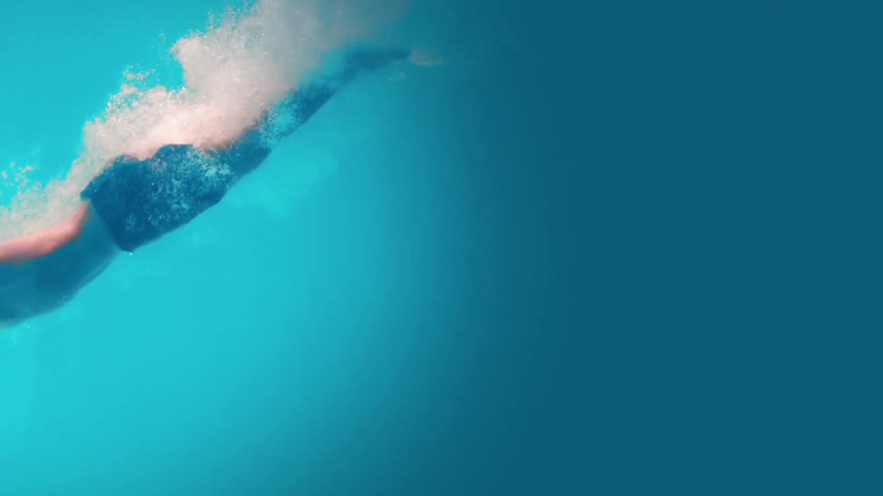 vista submarina de un hombre atlético buceando en la piscina