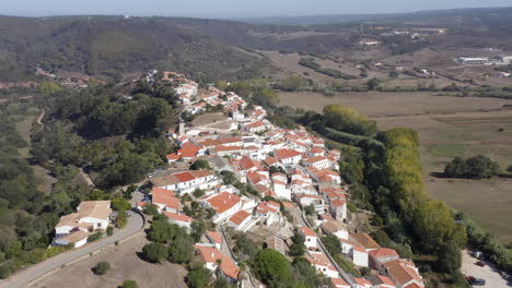 aerial drone flight towards the hills with view of a few villas in aljezur, algarve, portugal