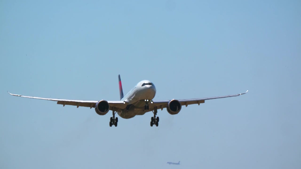 Aereo di linea in avvicinamento per l'atterraggio in un cielo azzurro e limpido