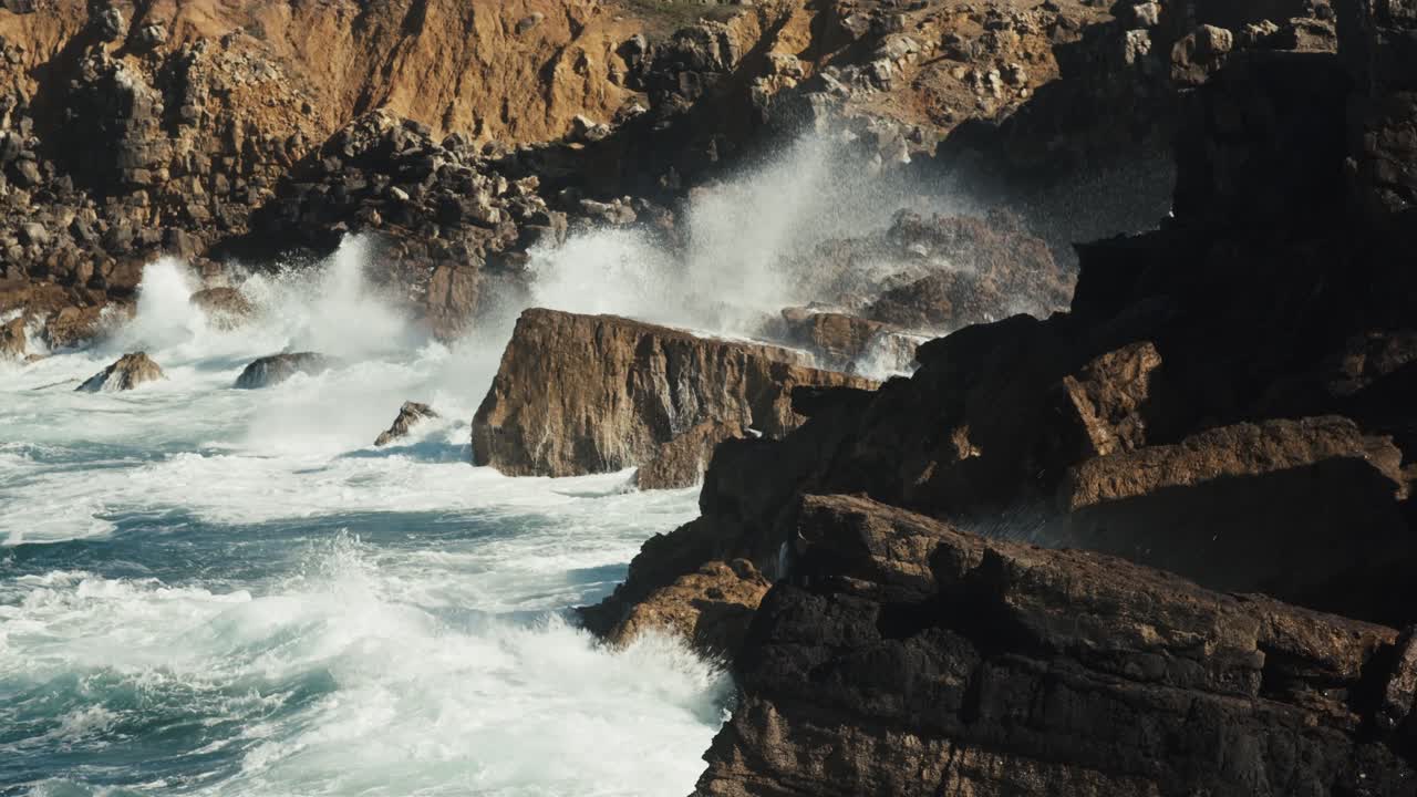 enormes olas rompiendo contra los acantilados