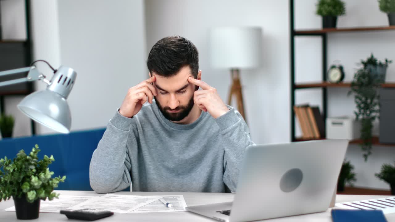 hombre de negocios cansado dolor de cabeza migraña presión arterial masaje de los templos en la oficina lugar de trabajo portátil